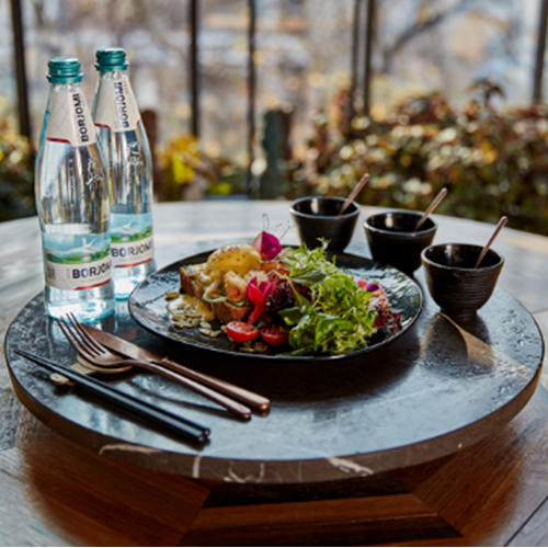 Woda Borjomi obok potraw na eleganckim stole